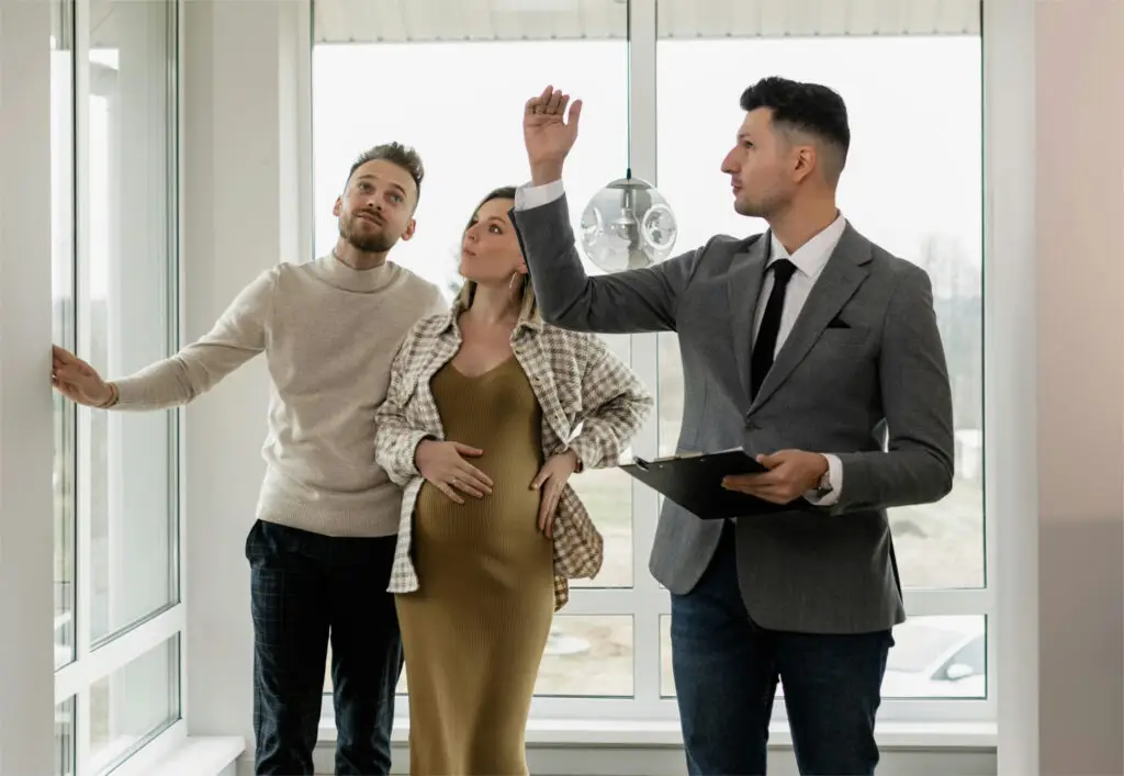 Couple viewing property; agent showing windows.